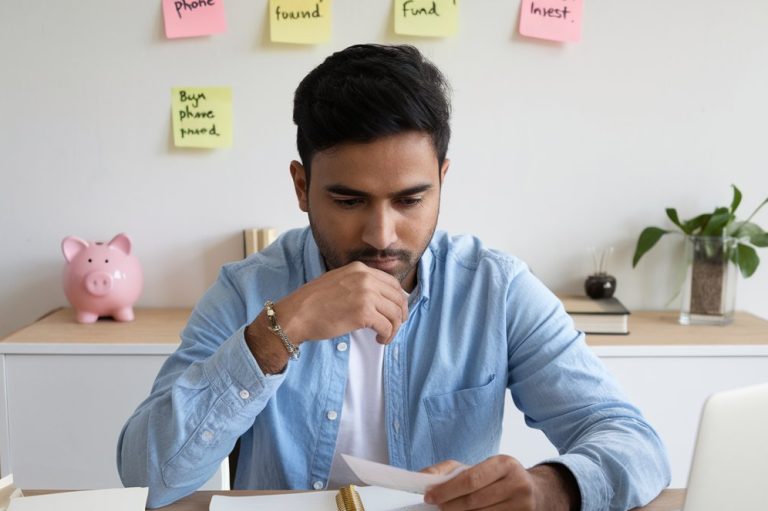 An Indian man is thinking about how to save money on a ₹10,000 salary